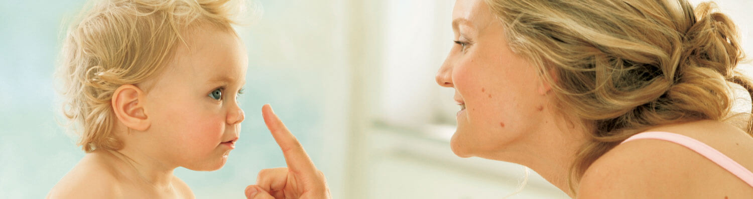 A woman and a child are engaged in a close, intimate moment.